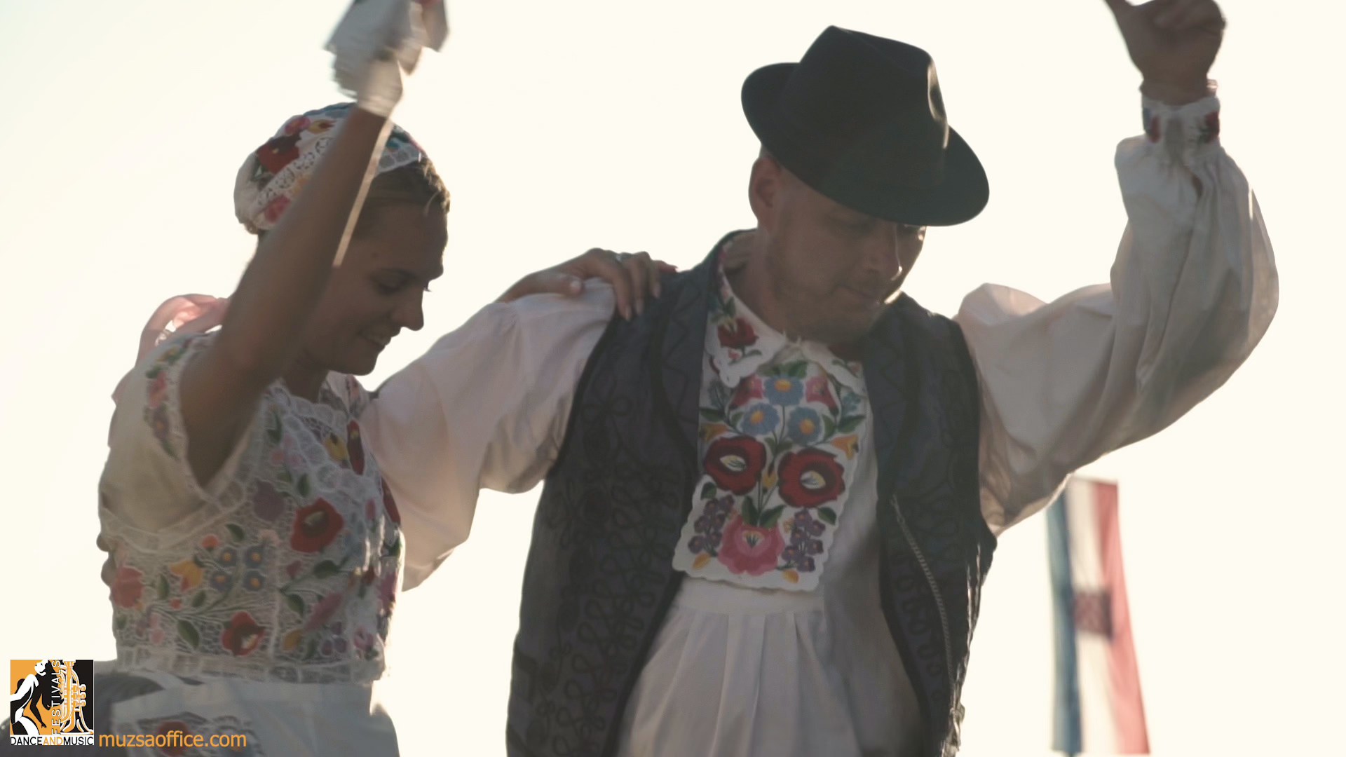 A colorful stage performance by a modern dance group at a European music and dance festival with an enthusiastic audience.